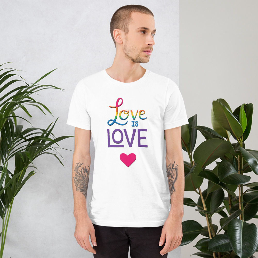 man wearing a love is love white t-shirt with a pink heart