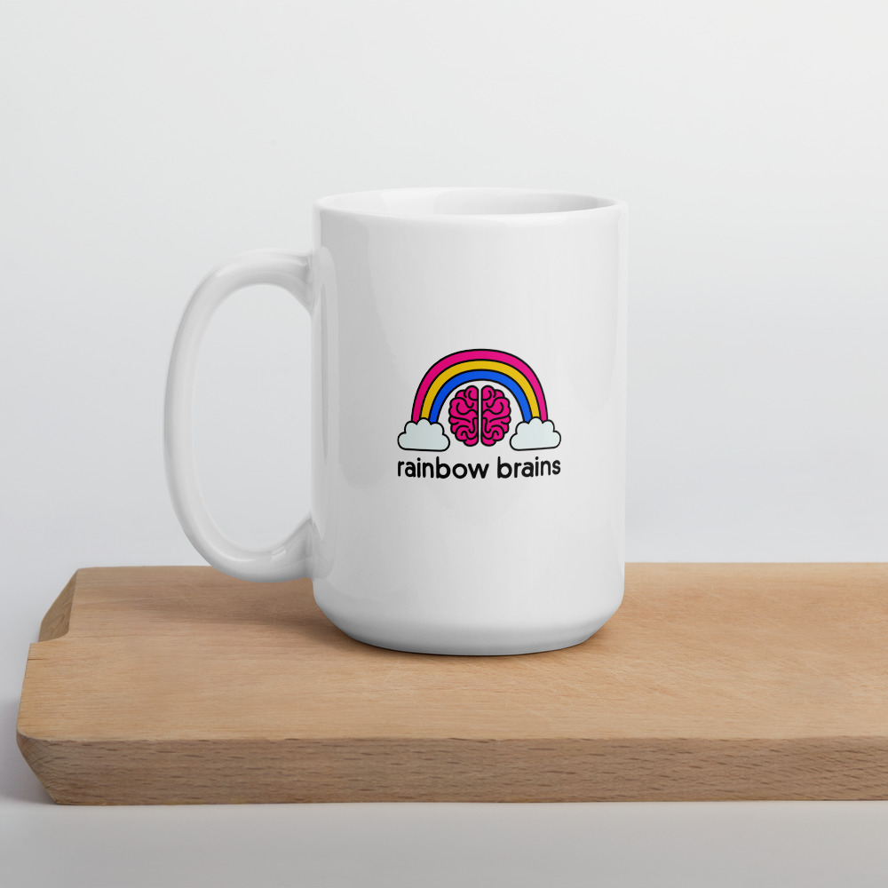 white mug with rainbow brains logo sitting on a wooden chopping block
