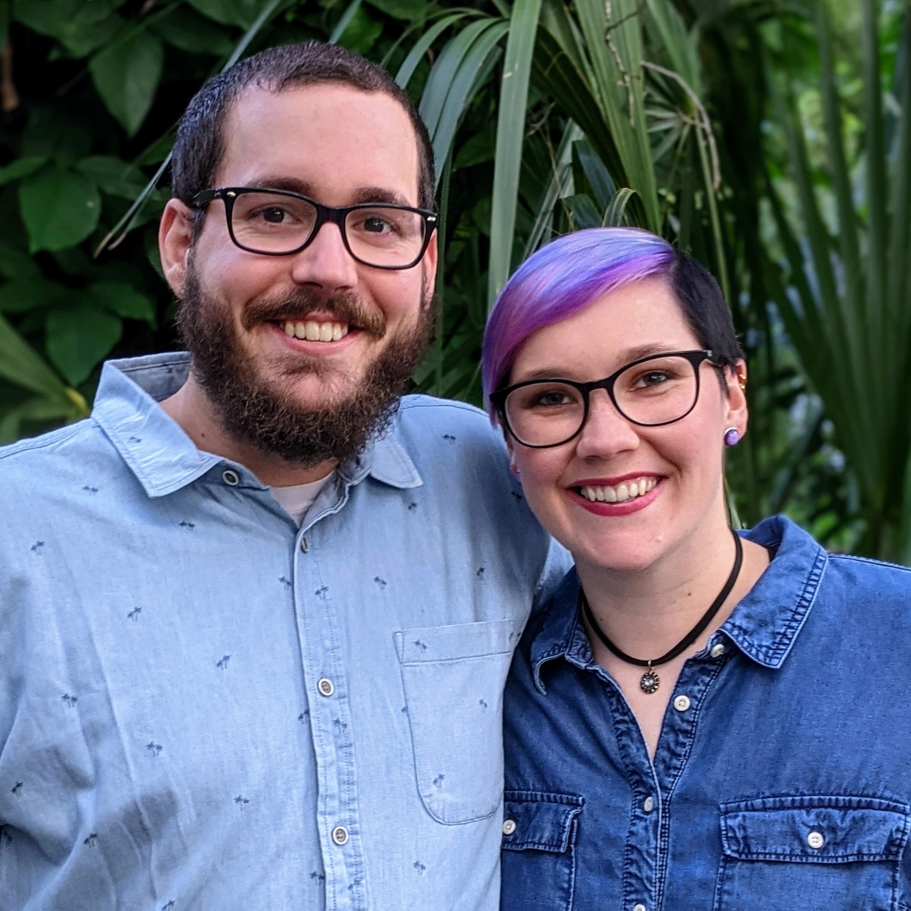Michael and Taylor, co-founders of Rainbow Brains smiling in front of foliage
